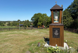 Kapliczka drewniana z figurą Matki Bożej, obok kościoła pw. św. Macieja Apostoła. Trzebicko, gmina Cieszków, powiat milicki, woj. dolnośląskie.