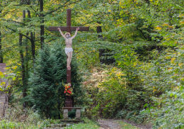 Krzyż drewniany z blaszaną figurą Chrystusa przy drodze wiodącej na szczyt Kalwari. Bardo, powiat ząbkowicki.