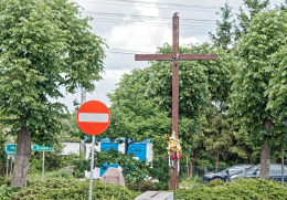 Przydrożny krzyż drewniany obok budynku Urzędu Gminy. Dmosin, powiat brzeziński, woj. Łódzkie.