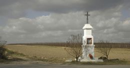 Krzyż przydrożny, metalowy na kamiennym postumencie, stojący przy drodze Białobrzegi - Mogielnica. Pacew, gmina Promna, powiat białobrzeski.