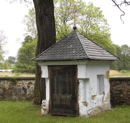 Kapliczka domkowa stojąca przy murze kościelnym. Jasionna, gmina Białobrzegi, powiat białobrzeski.