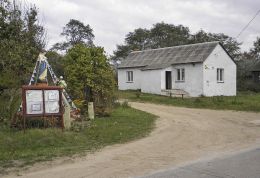 Przydrożna kapliczka stojąca obok wiejskiej świetlicy. Koryciska, gmina Wieniawa, powiat przysuski.