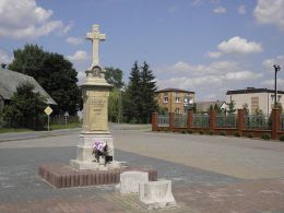 Krzyż przydrożny z 1906 r. w centrum wsi, na przykościelnym parkingu. Odechów, gmina Skaryszew, powiat radomski.
