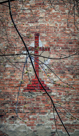 Krzyż z cegieł w ścianie kamienicy przy ulicy Strzeleckiej 31. Warszawa, Praga Północ.