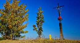 Przydrożny krzyż metalowy na kamiennym postumencie. Bisztynek - Kolonia, gmina Bisztynek. Powiat bartoszycki, woj. warmińsko-mazurskie.