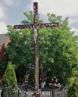 Drewniany krzyż przydrożny w centrum wsi.